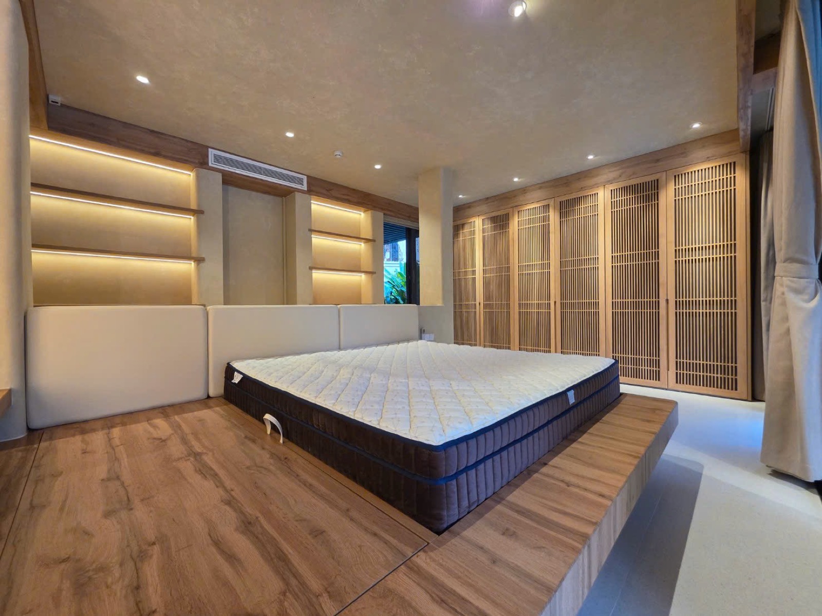 Toàn cảnh phòng ngủ villa Phú Mỹ Hưng — tường trần vân bê tông liền mạch và tủ lam gỗ